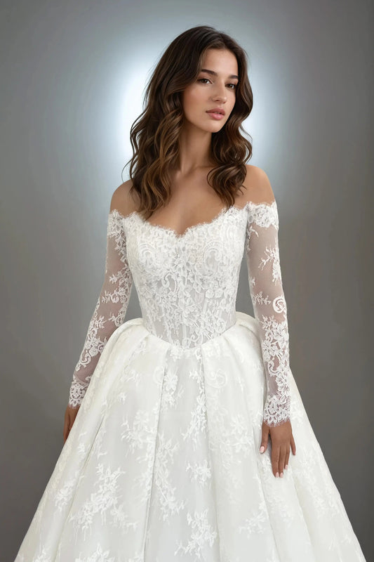 Front view of the Annabelle lace ball gown wedding dress featuring an off-the-shoulder neckline, long sheer sleeves, drop waist, and corded lace bodice.