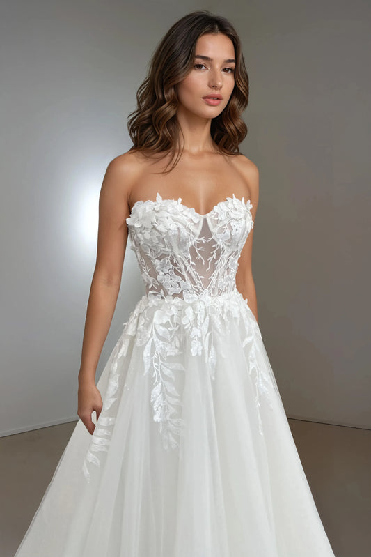 Close-up front view of the Daphne strapless A-line wedding dress showcasing a sheer bodice with leaf-shaped lace appliqués that softly cascade down the tulle skirt.