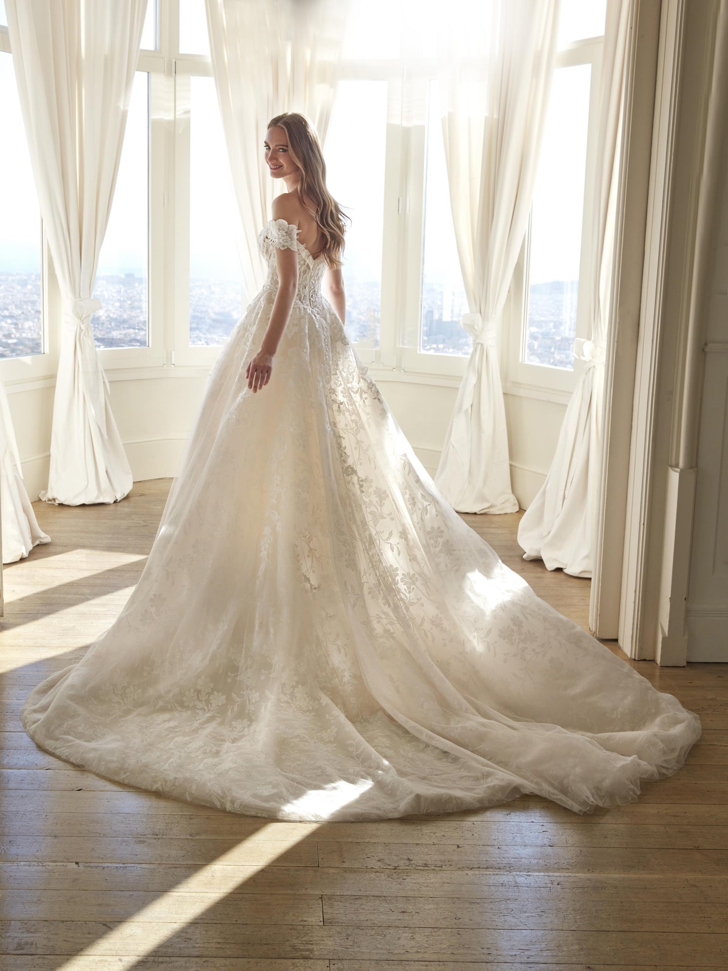 Back view of the Juddy princess wedding dress featuring off-the-shoulder floral straps and a glitter tulle skirt with cathedral train.