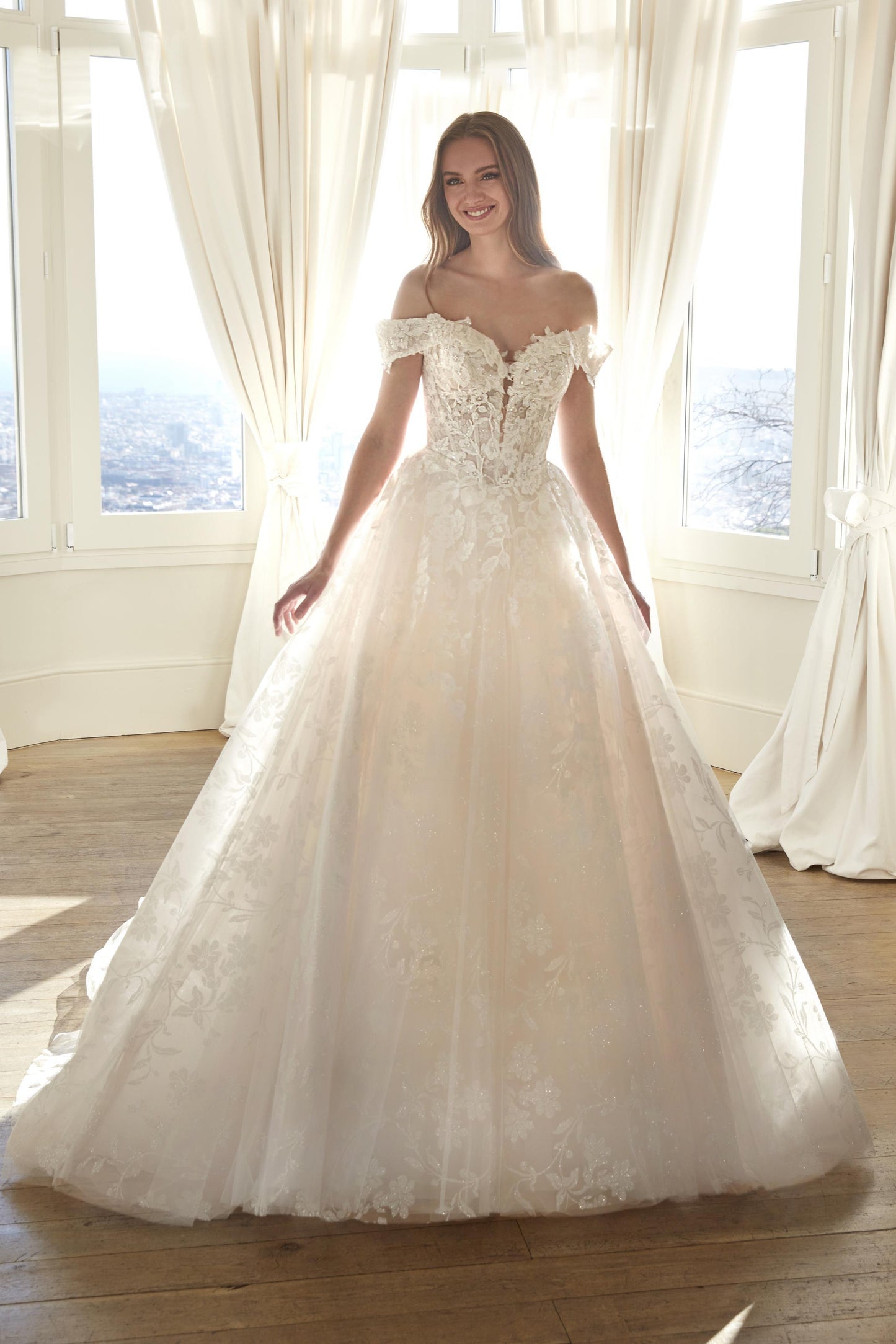 Front view of the Juddy sparkly princess wedding dress featuring off-the-shoulder floral straps, a subtle drop waist, and a glitter tulle skirt.