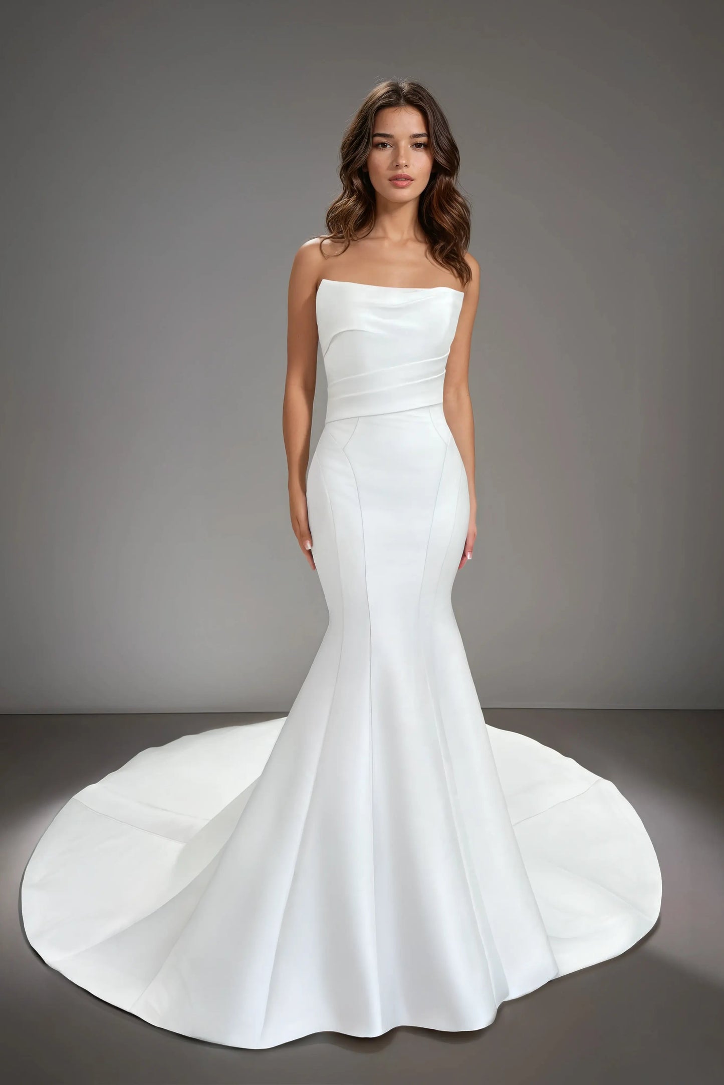 Front view of the Tess strapless Mikado mermaid wedding dress featuring a straight neckline, structured seams, and a minimalist silhouette with a long train.