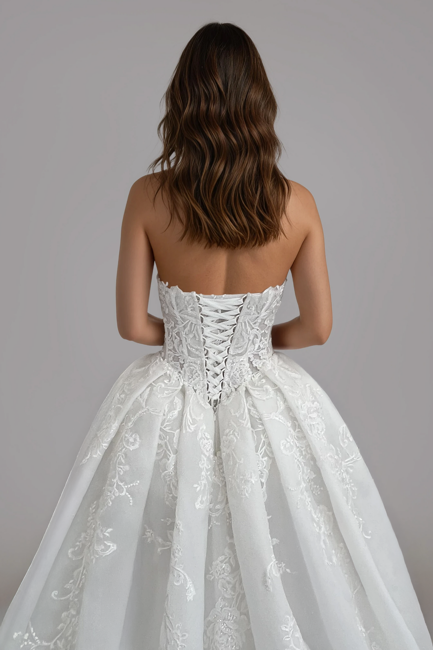 Close-up back view of the Victoria wedding dress featuring a lace-up corset back, floral lace bodice, and voluminous organza skirt.