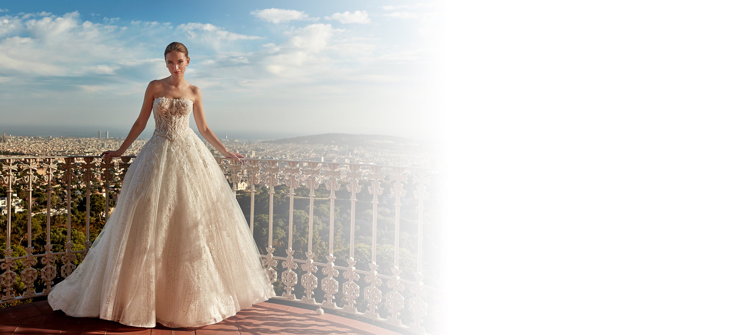 Strapless lace ball gown wedding dress from the House of St. Patrick 2026 collection at Krismil Bridal with city view.