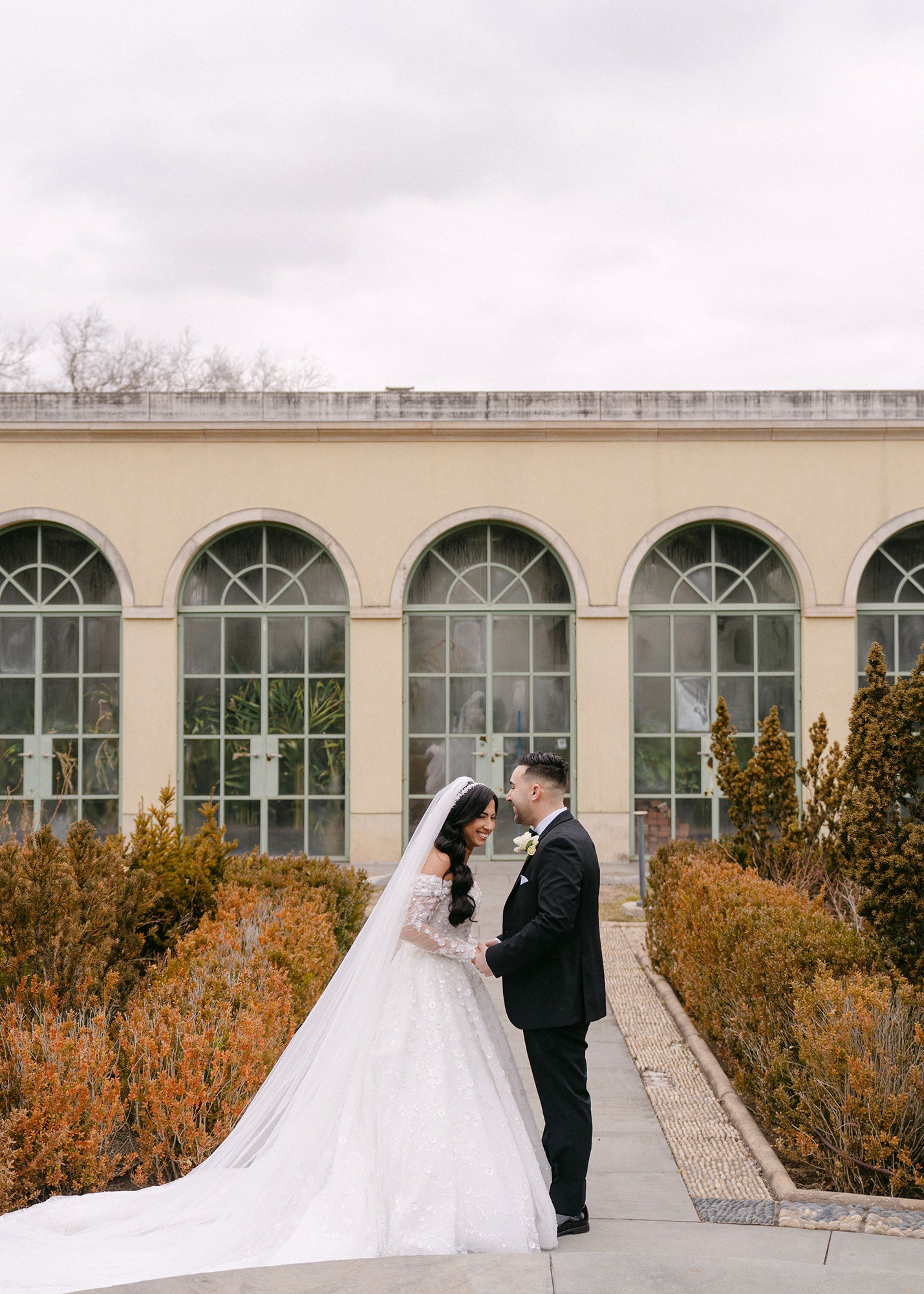 Krismil Bride Lead wearing a sparkly A-line wedding dress with sleeves at a botanical garden wedding.