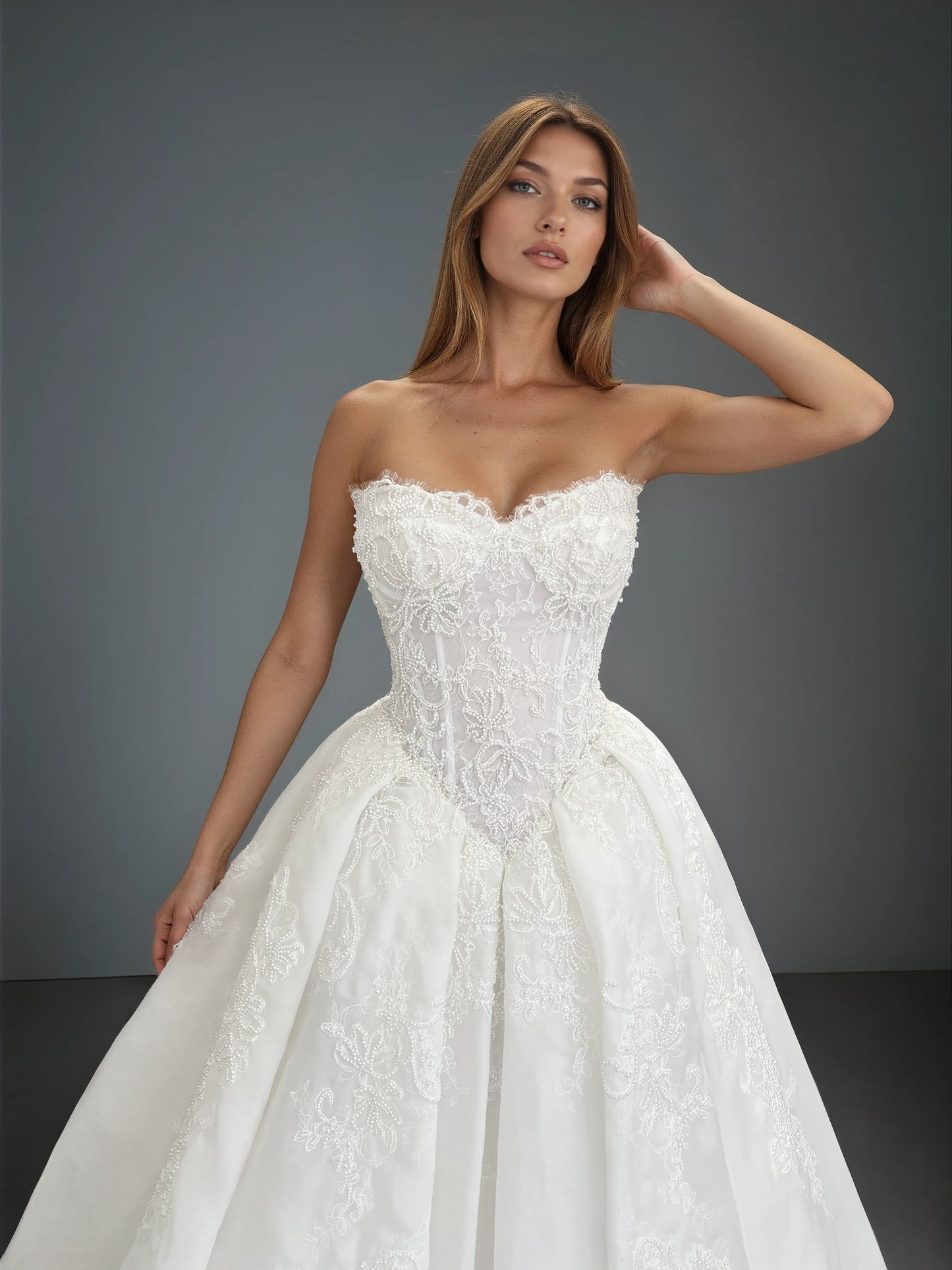 Close-up front view of the Claudia ball gown wedding dress showcasing a strapless pearl-embellished lace bodice with a basque waist and a pleated organza ball gown skirt.