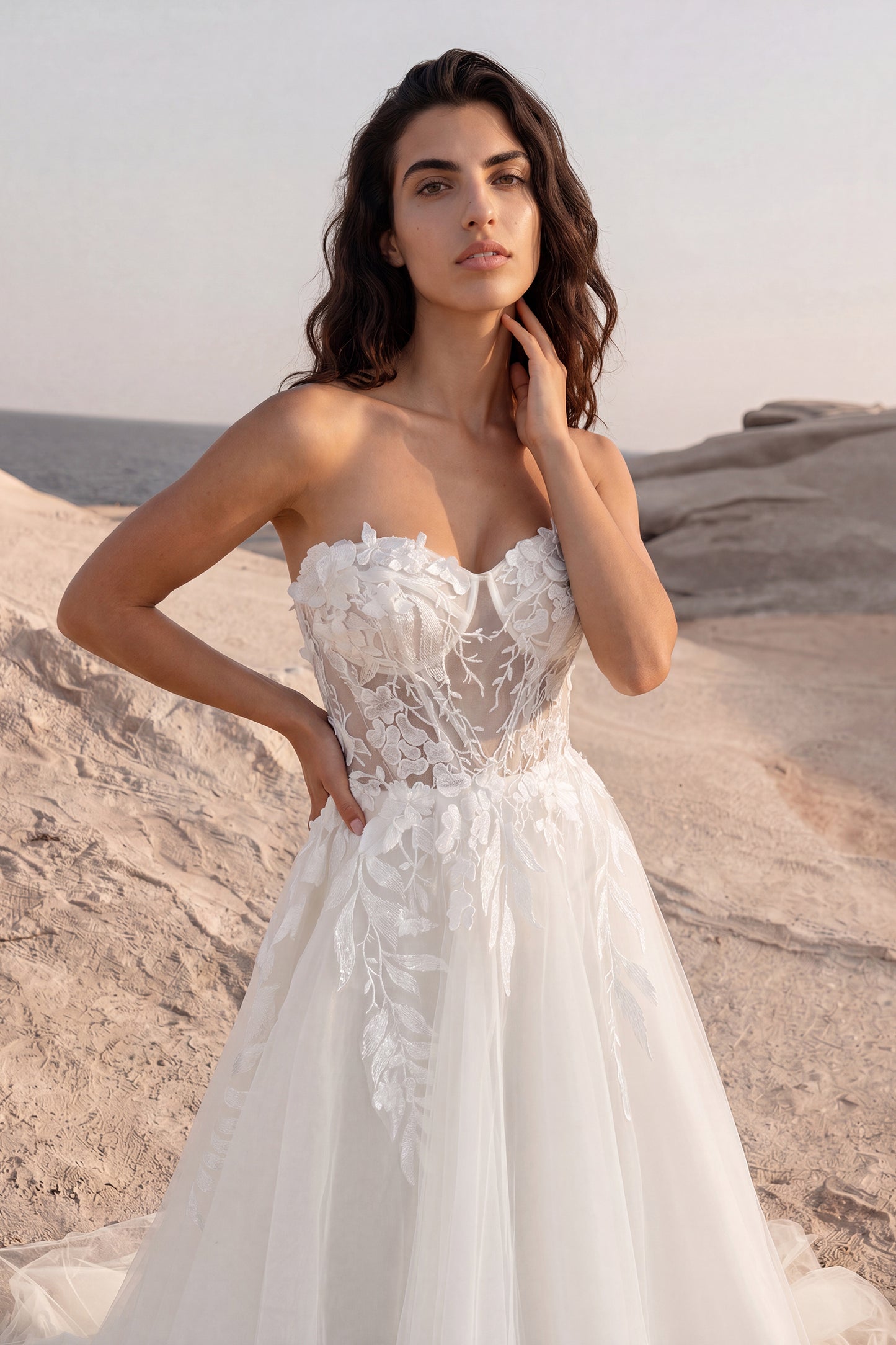 Close-up front view of the Daphne strapless A-line wedding dress showcasing a sheer bodice with leaf-shaped lace appliqués that softly cascade down the tulle skirt.