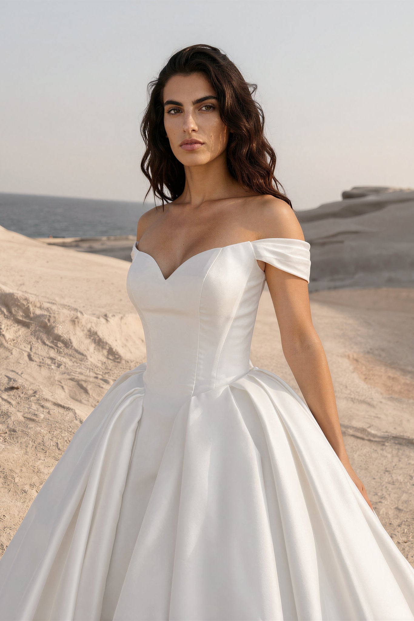 Close-up front view of the Eliana wedding dress featuring an off-the-shoulder sweetheart neckline, structured Mikado skirt, and basque waist.