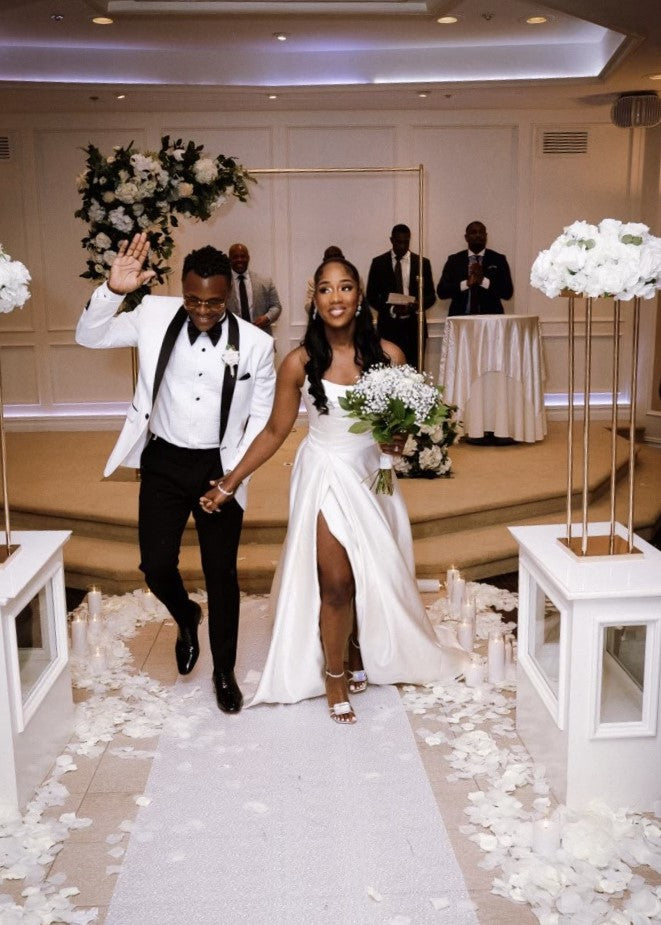 Bride Jessica in a strapless gown with a thigh-high slit by Krismil Bridal, walking down the aisle with her husband after their New York wedding ceremony.