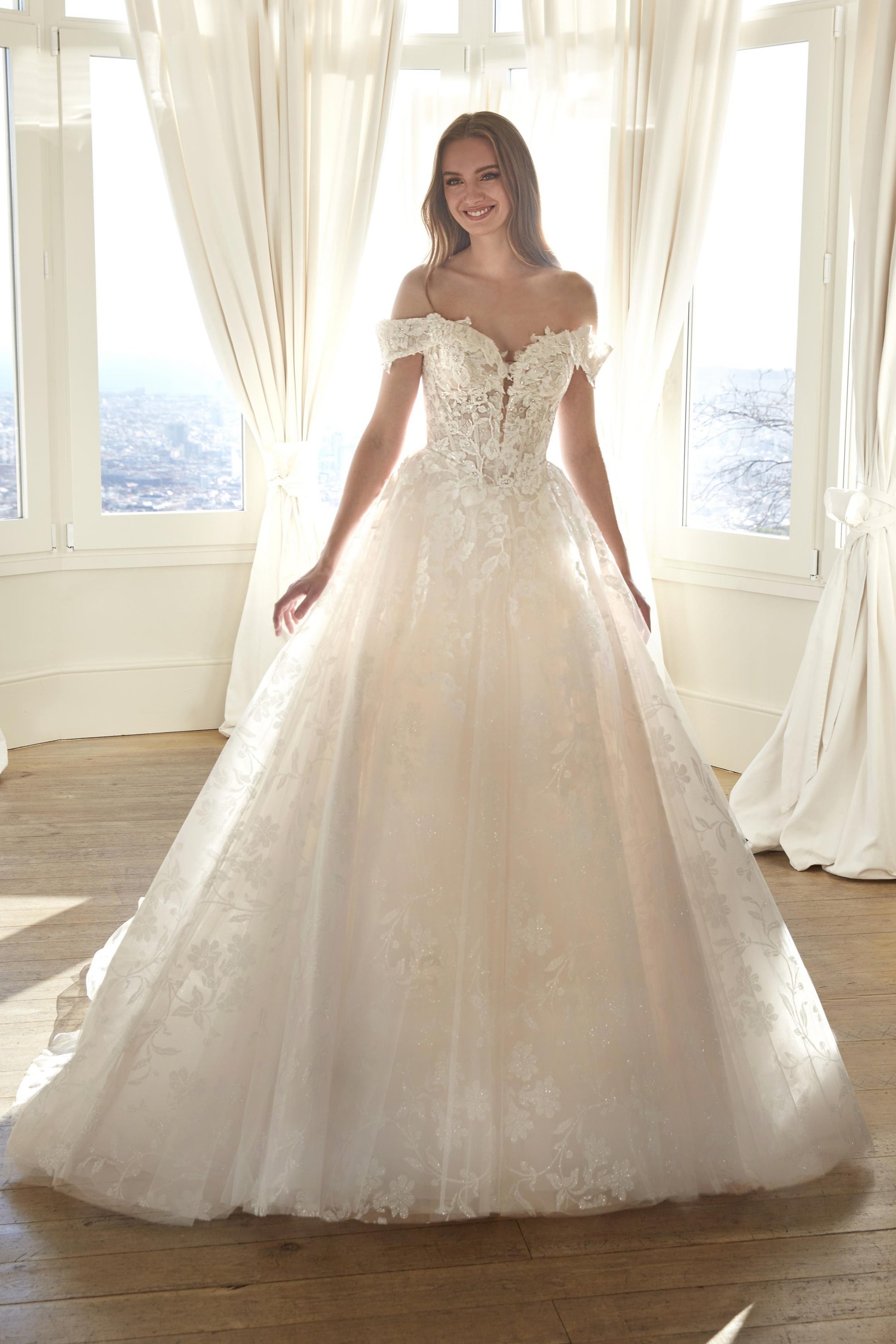 Front view of the Juddy sparkly princess wedding dress featuring off-the-shoulder floral straps, a subtle drop waist, and a glitter tulle skirt.
